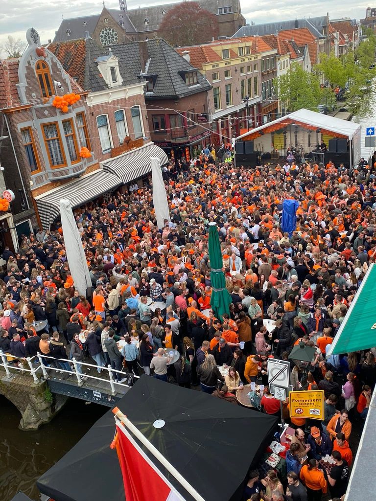 Koningsdag op de Platte Stenen Brug: de hele brug vol mensen in het oranje